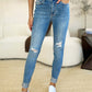 Woman wearing Judy Blue Jeans Mid Rise Destroy & Cuff Skinny Jeans with destroyed detailing and cuffed hem, shown with a white top and sneakers