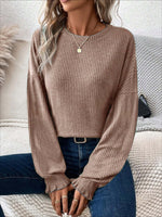 Woman wearing Bella Road Ribbed Round Neck Lantern Sleeve T-Shirt sitting on couch.