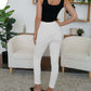 Woman modeling white FAM-FAM High Waist Skinny Pants with black top in stylish living room setting.