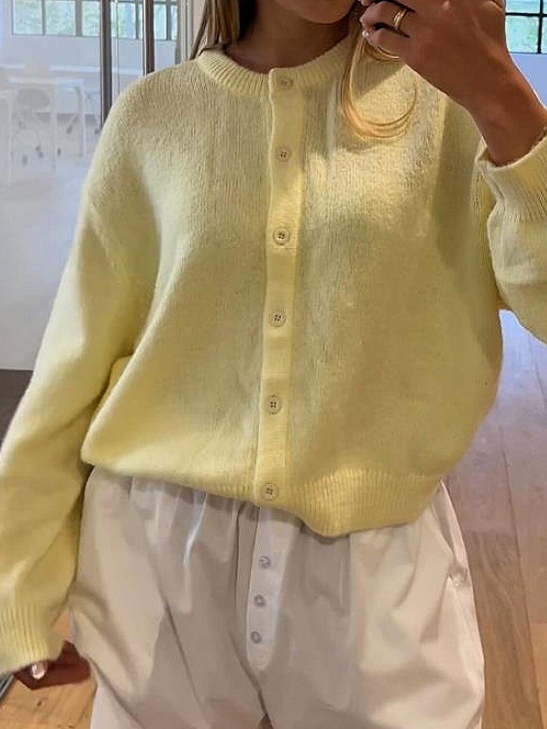 Model wearing a pastel yellow Bella Road Button Down Long Sleeve Cardigan, featuring a cozy buttoned design.