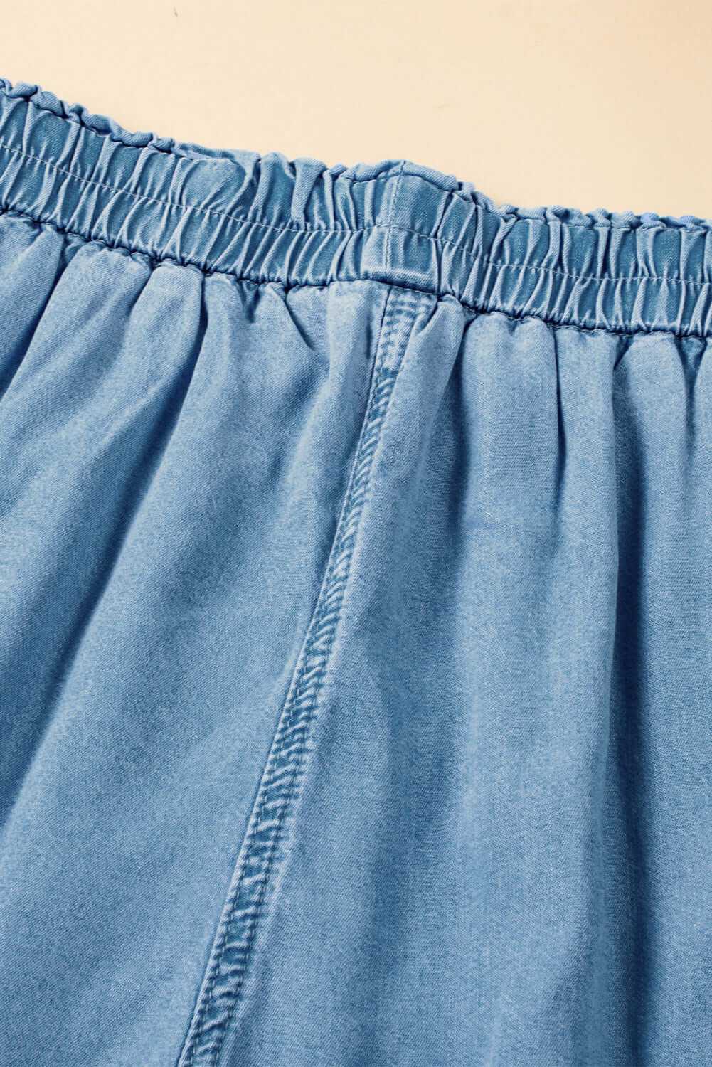 Close-up of the drawstring waistband on Bella Road denim wide leg jeans in light wash.