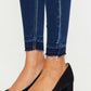 Stylish high-rise ankle skinny jeans with release hem detail, paired with chic black heels for a trendy look.