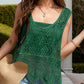 Stylish woman in green Bella Road Swim Cutout Cover-Up, holding a hat and showing off lace details outdoors.