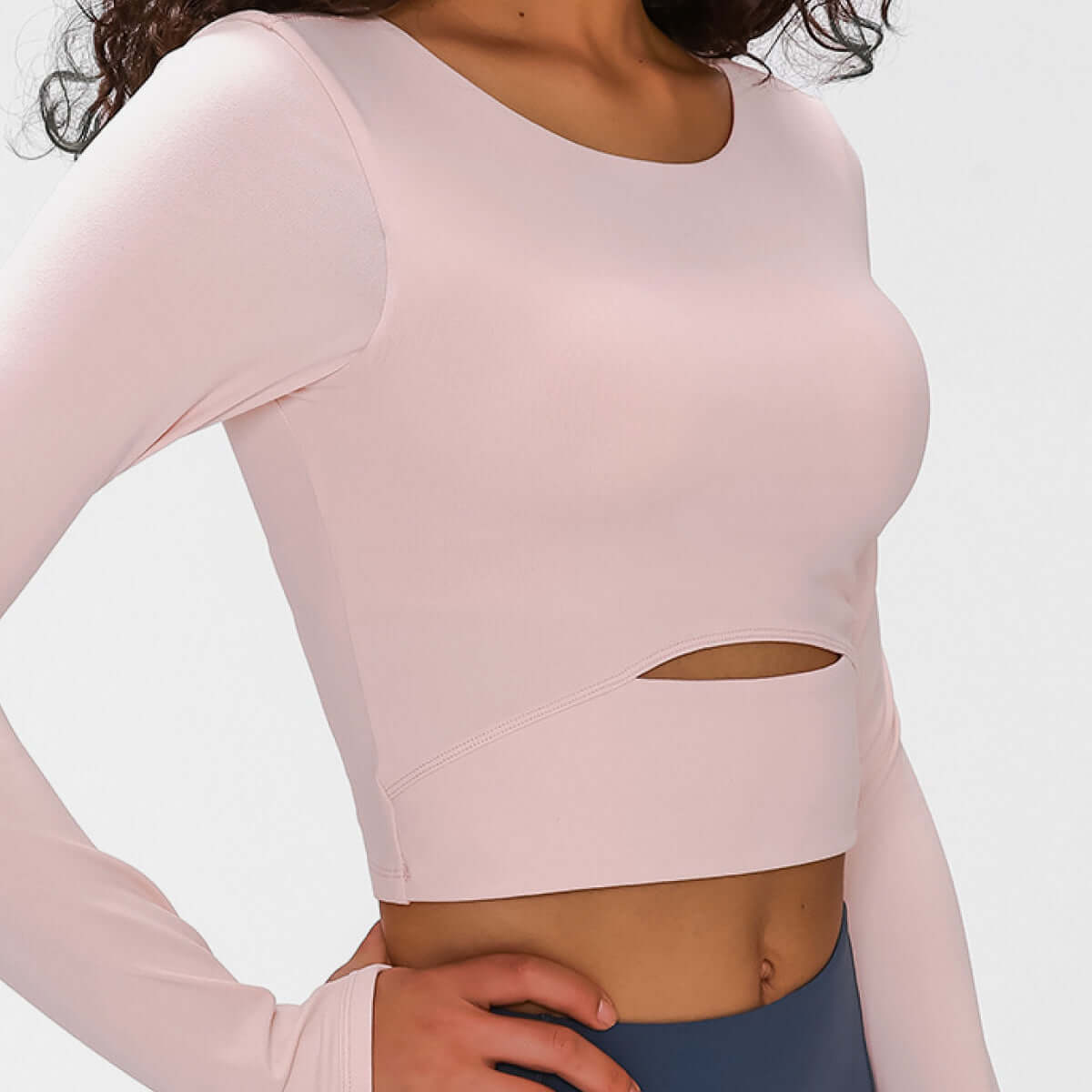 Millennia long sleeve cropped top in soft pink, featuring a stylish cutout and support strap for comfort and style.