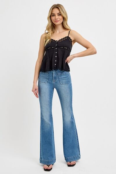 Model wearing RISEN plus size front patch pocket flare jeans with a stylish black top, highlighting trendy vintage fashion.