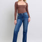 Model showcasing Judy Blue side seam detail straight jeans with pockets, styled with a fitted brown top and strappy heels.