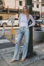 Woman wearing 90's Vintage Super High Rise Flare Jeans standing on city street