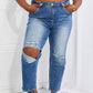 Model wearing Emily High Rise Relaxed Jeans with ripped knee detail by Risen Jeans, showcasing ultra-high waist, cropped length, and casual style.