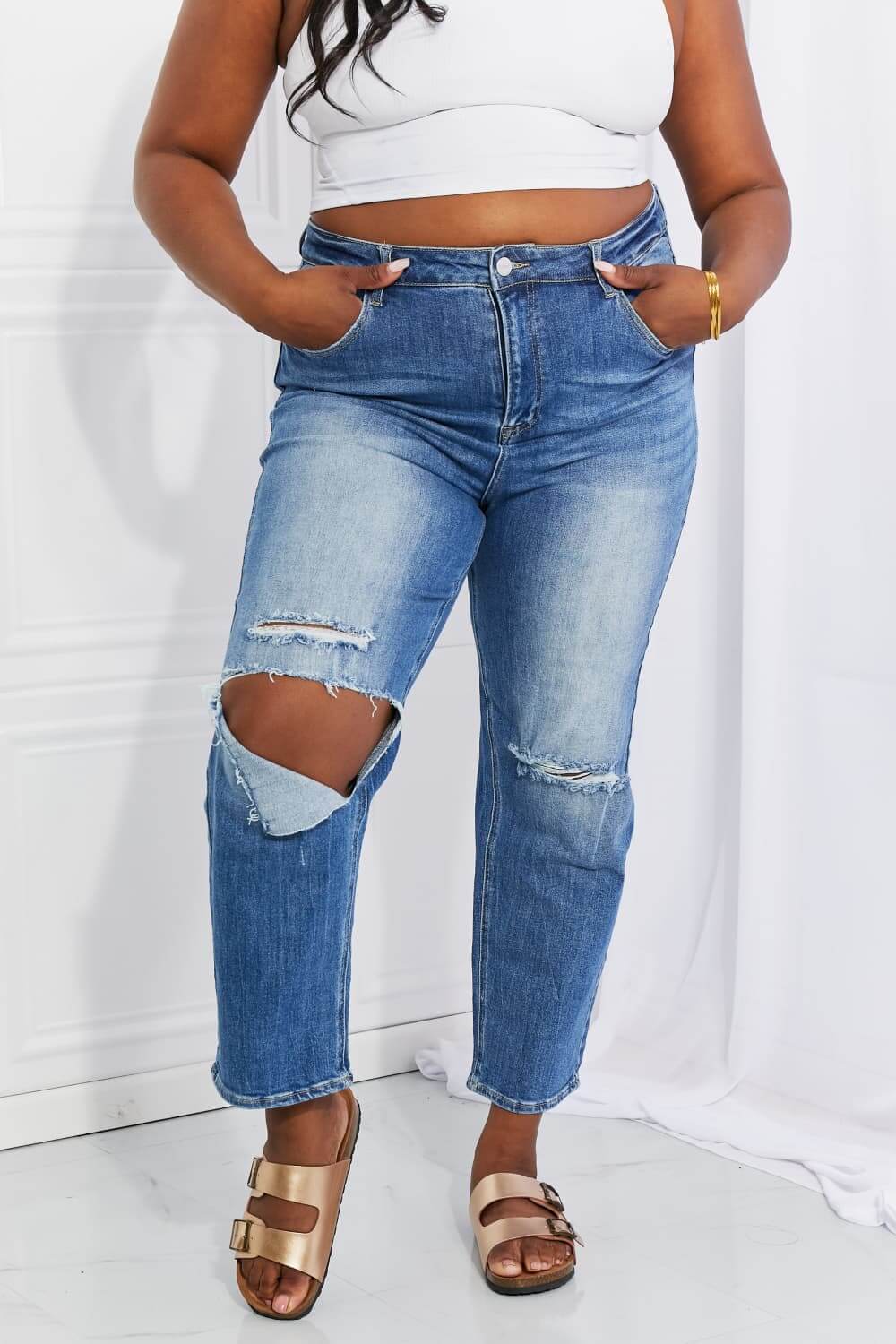 Model wearing Emily High Rise Relaxed Jeans with ripped knee detail by Risen Jeans, showcasing ultra-high waist, cropped length, and casual style.