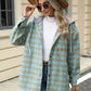 Woman wearing Bella Road Drawstring Plaid Long Sleeve Hooded Jacket with white sweater and jeans, accessorized with sunglasses and hat