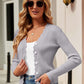 Woman wearing Bella Road Button Up Long Sleeve Cardigan in gray with sunglasses, white top, and jeans, posing outdoors.