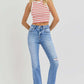 Woman wearing RISEN high-rise ankle straight jeans with distressed details and a striped top.