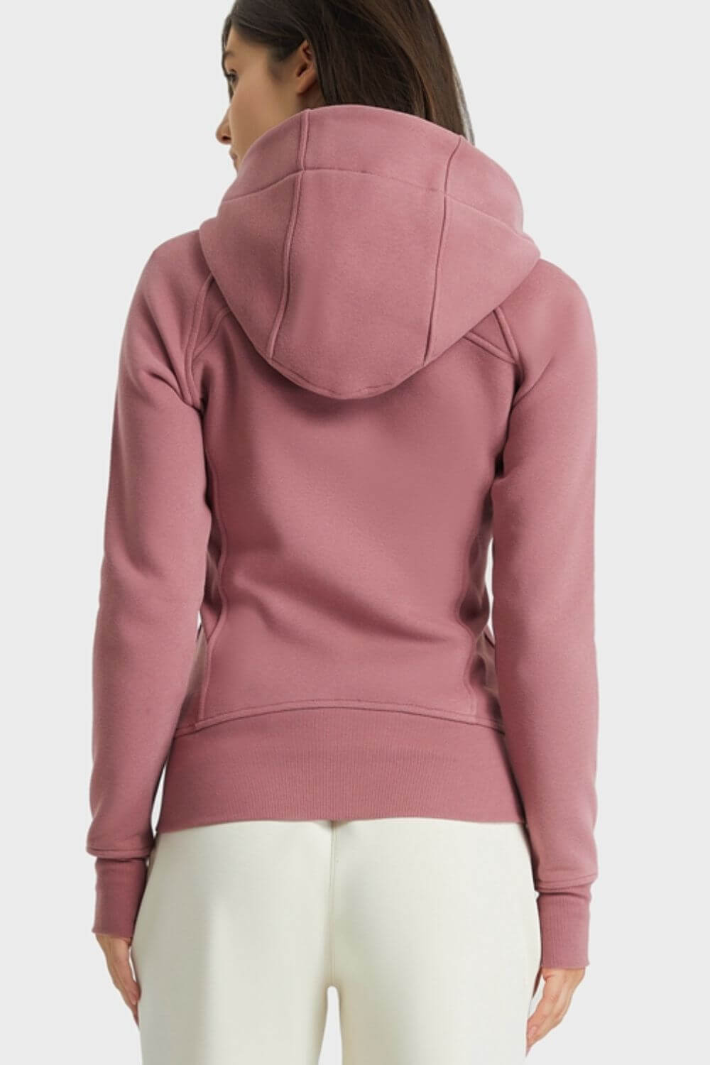 Back view of Millennia Zip Up Hooded Sports Jacket in soft pink, showcasing cozy hood and seam details, ideal for outdoor activities.