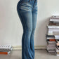 Stylish woman in mid rise bootcut jeans showcasing a trendy fit and functional pockets against a minimalist background.