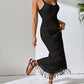 Woman wearing a black openwork scoop neck cover-up dress with sheer tassels in a stylish semi-sheer look.