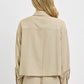 Back view of a woman wearing a beige RISEN Button Down Long Sleeve Shirt, showcasing the classic style.