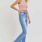 Woman wearing RISEN distressed high-rise ankle straight jeans with a striped tank top, showcasing casual and trendy style.