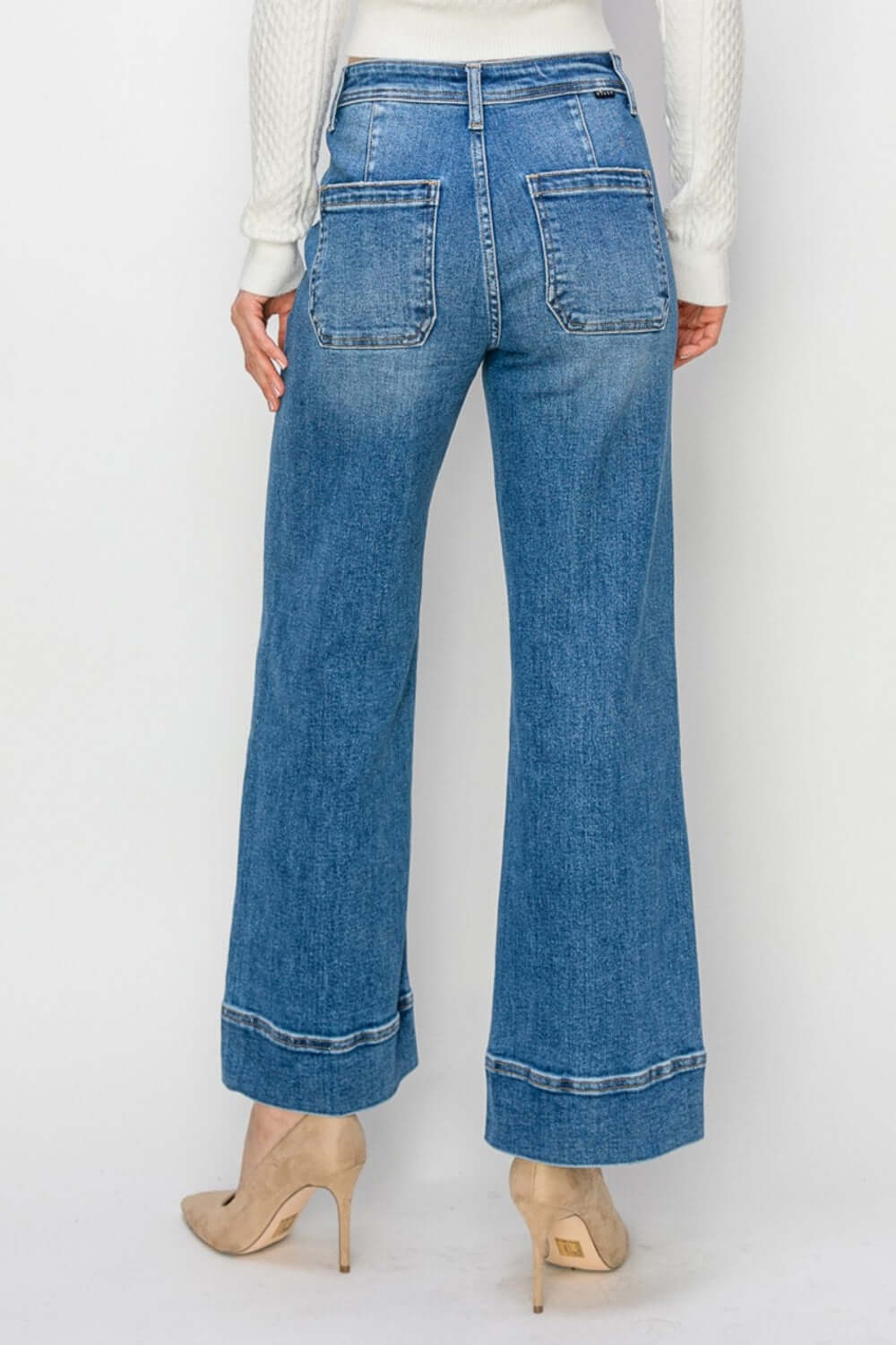 Woman wearing High Rise Wide Leg Jeans by Risen Jeans with a chic retro-inspired look and comfortable wide leg design.