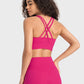 Model showcasing the Millennia Crisscross Scoop Neck Active Tank in vibrant pink, highlighting stylish back design.