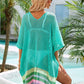 Woman wearing a teal slit openwork V-neck half sleeve cover-up by the pool with palm trees in the background