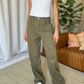 High-rise garment dye wide leg jeans in rich olive color paired with a white tank top for a stylish and comfortable look