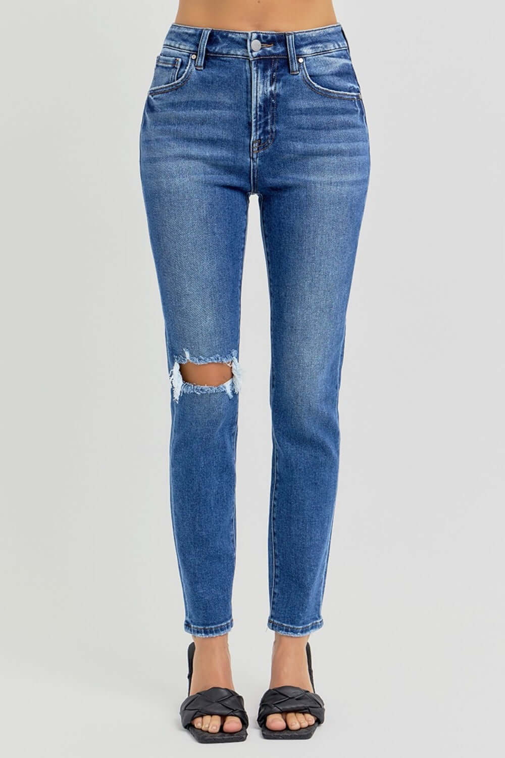 High rise ankle skinny jeans with knee distressing in blue denim featuring flattering fit and trendy cropped length.