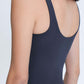 Back view of a woman wearing a sleek Millennia V Neck Active Tank in dark navy, showcasing its soft and stretchy fabric.