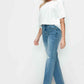 Model in distressed high rise straight jeans paired with a chic white top and trendy heels, showcasing stylish denim fashion.