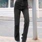 Bella Road Side Slit High Waist Jeans with Pockets in black, worn by model standing outdoors, showcasing stylish side slits and flattering fit.