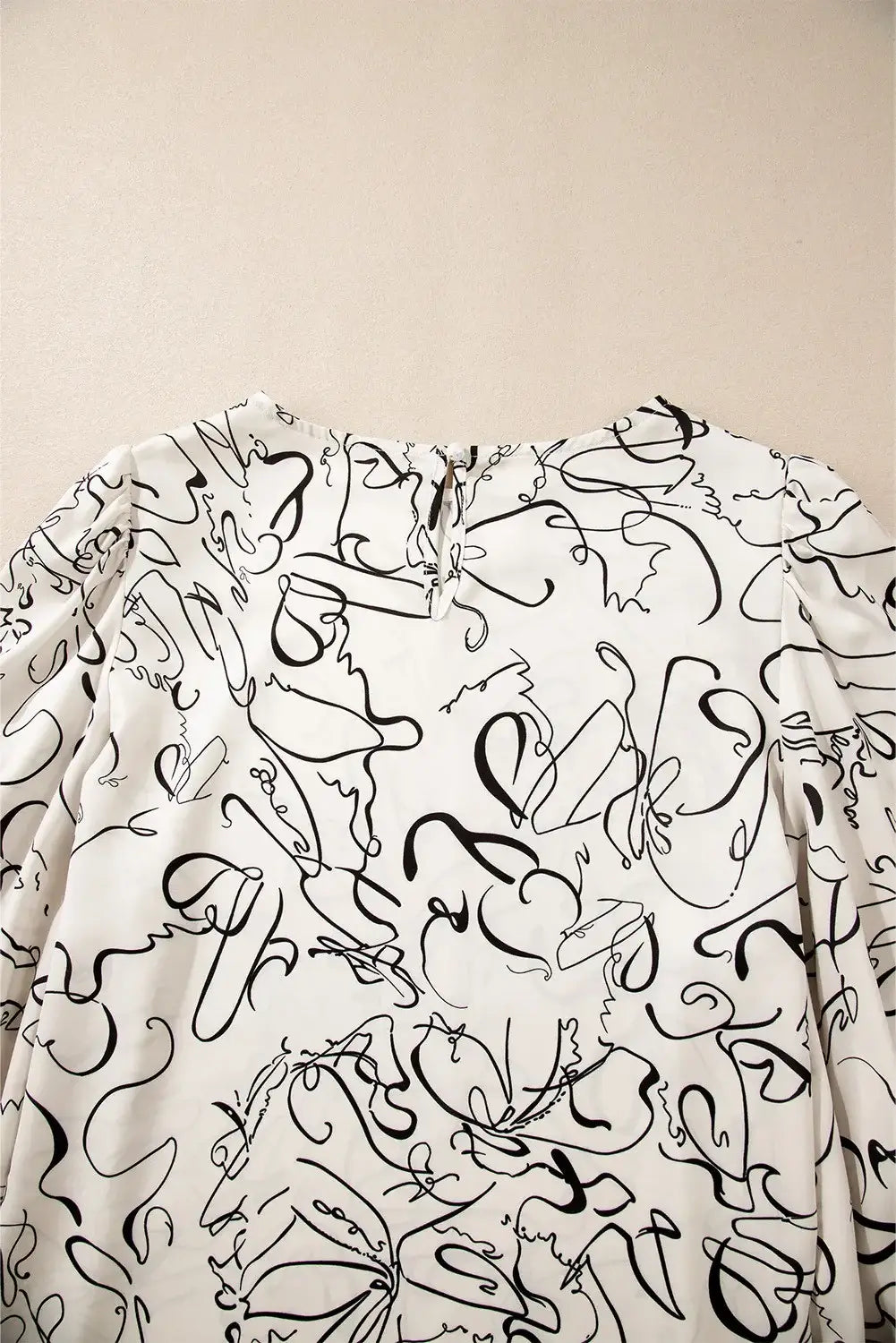 Printed round neck three-quarter sleeve blouse with abstract black and white design on back view