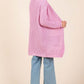 Stylish pink longline cardigan with open front and long sleeves, paired with light blue jeans for a chic look.