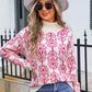 Woman wearing Angel Wings Flower Turtleneck Sweater with pink floral design, paired with stylish hat and sunglasses.