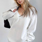 Woman wearing a white Basic Bae V-Neck Dropped Shoulder Long Sleeve Sweatshirt with Bra and holding a black bag