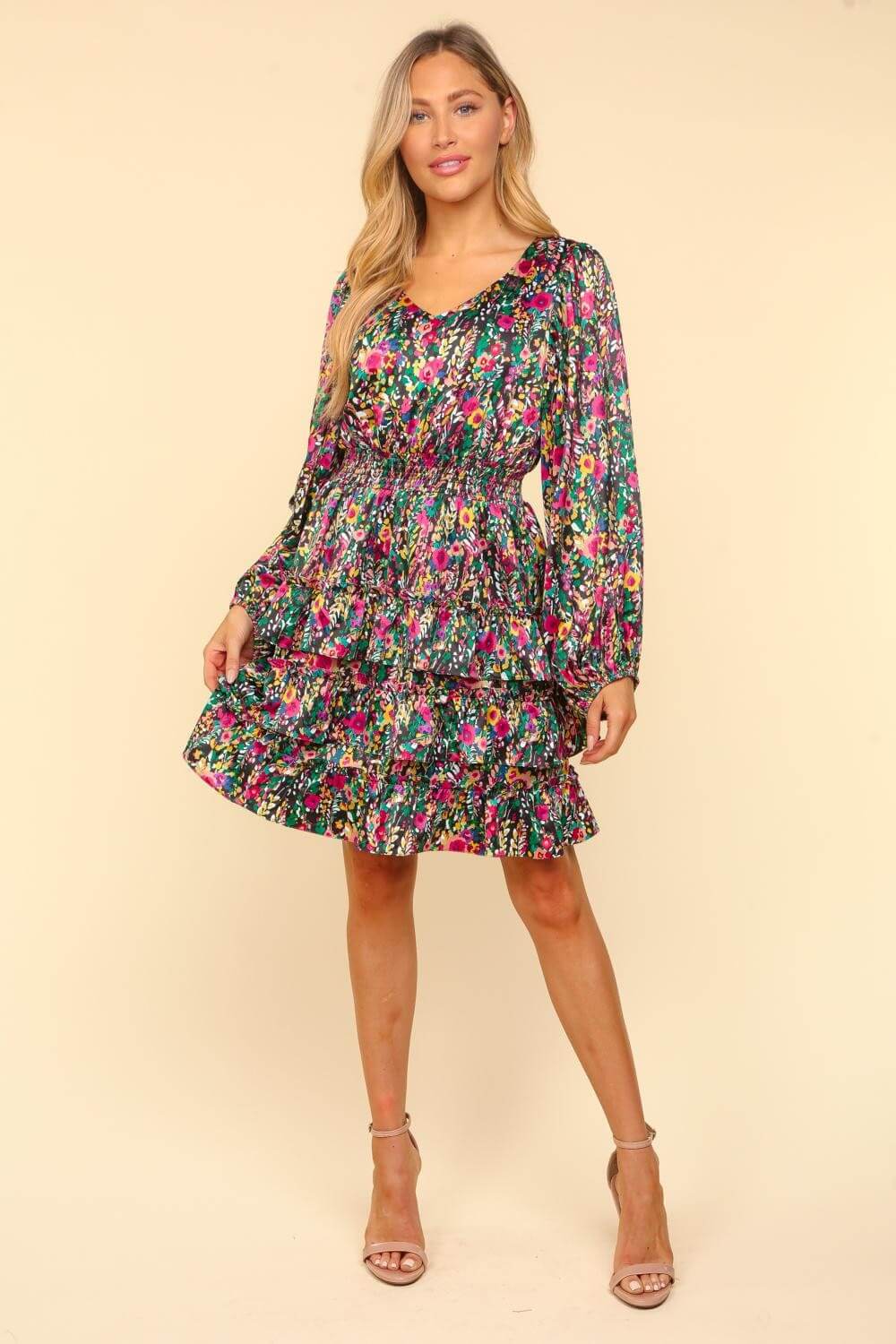 Woman wearing a colorful floral V-neck satin layered dress, showcasing elegance and femininity with a flowy silhouette.