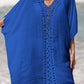 Woman wearing a blue cutout V-neck three-quarter sleeve cover-up on the beach.