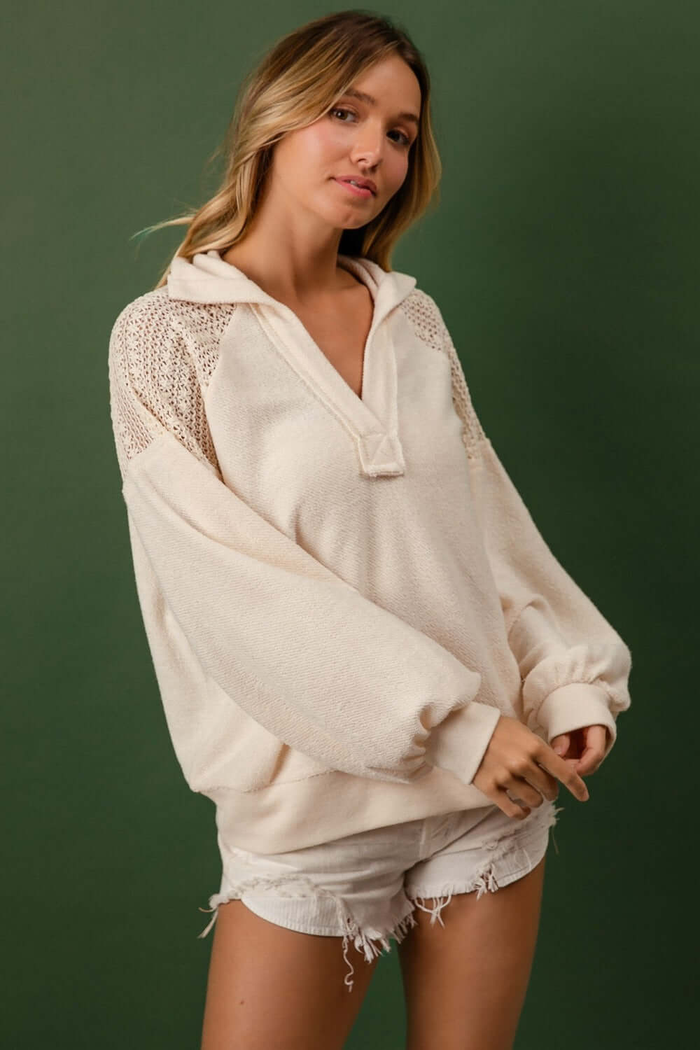 Woman wearing BiBi French Terry Lace Shoulder Top with casual shorts, showcasing the top's lace detailing and cozy fabric.