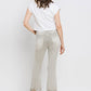 Woman wearing Lovervet distressed raw hem cropped flare jeans with a white top and heels, showcasing the back view of the jeans.