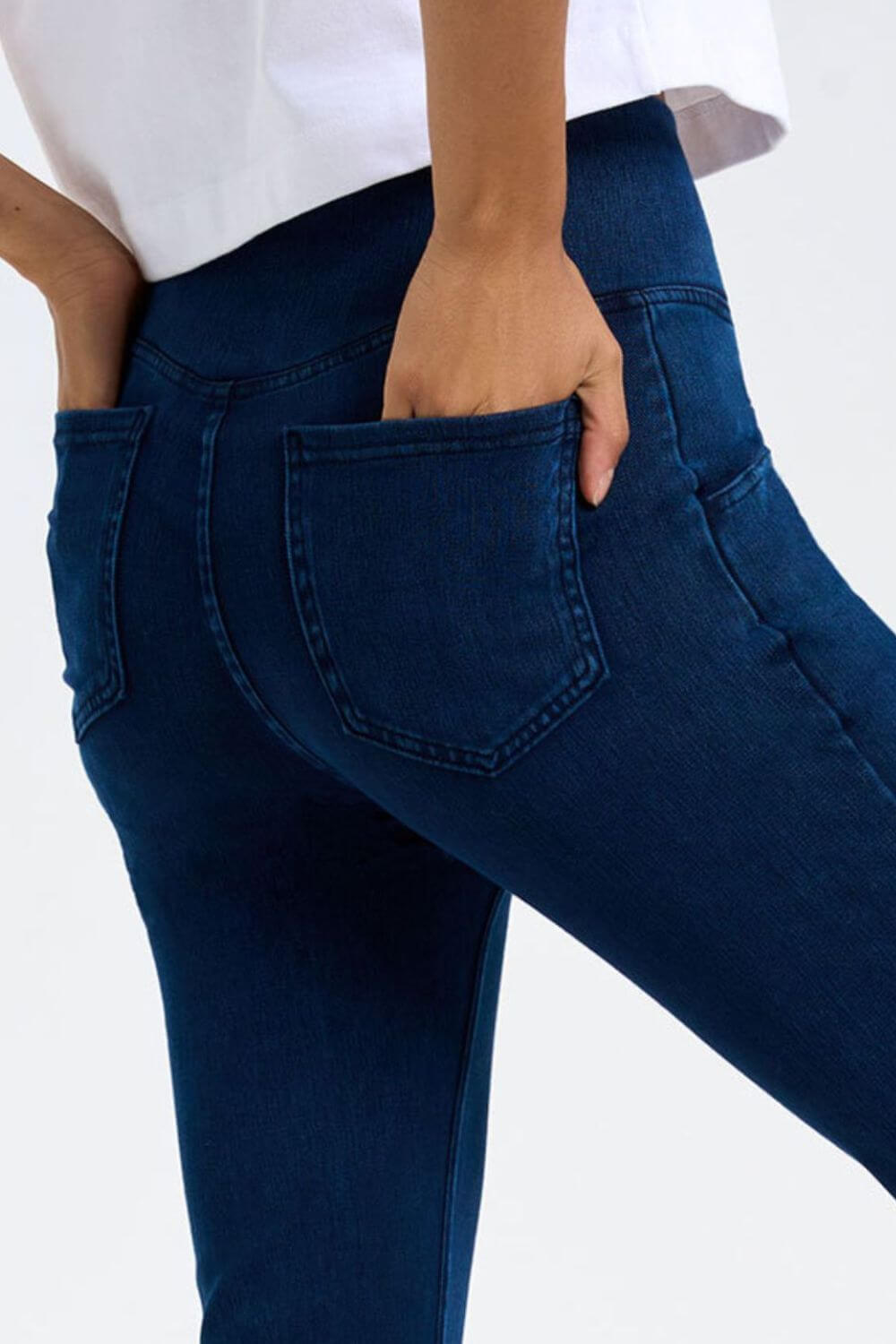 Model showcasing the pocket detail of Basic Bae Pocketed Highly Stretchy Bootcut Jeans in a rich blue color.