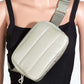 Stylish quilted nylon crossbody bag in light green, worn on a mannequin showcasing its practical design and easy carry style.