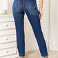 Woman wearing high waist released hem slit Judy Blue Jeans in deep indigo wash, back view showing slim silhouette and sophisticated design.