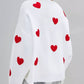 Woman wearing Bella Road Heart Round Neck Dropped Shoulder Sweater with red heart details from back.