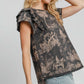 Woman wearing a chic ruffled landscape print short sleeve French terry top, showcasing a playful and stylish design.