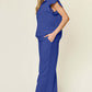 Woman wearing a blue texture ruffle short sleeve top and drawstring wide leg pants set with pockets.