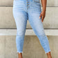 Woman wearing Judy Blue Button Fly Raw Hem Jeans with a casual look. Featuring pockets, moderate stretch, and comfortable material.