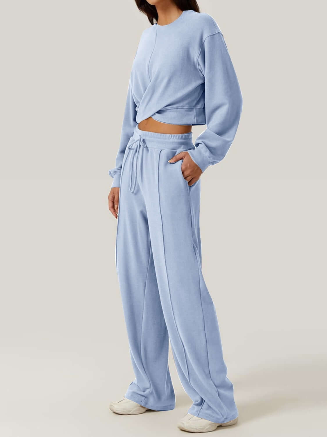 Woman wearing Bella Road Crisscross Round Neck Top and Drawstring Pants Set in light blue, showcasing stylish and comfortable two-piece outfit.