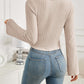 Woman wearing Bella Road Ribbed Drawstring Long Sleeve T-Shirt in beige with slightly stretchy material, viewed from the back.