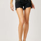 Woman wearing Frayed Hem Denim Shorts with Fringe Detail Pockets by Risen Jeans, perfect for casual summer style