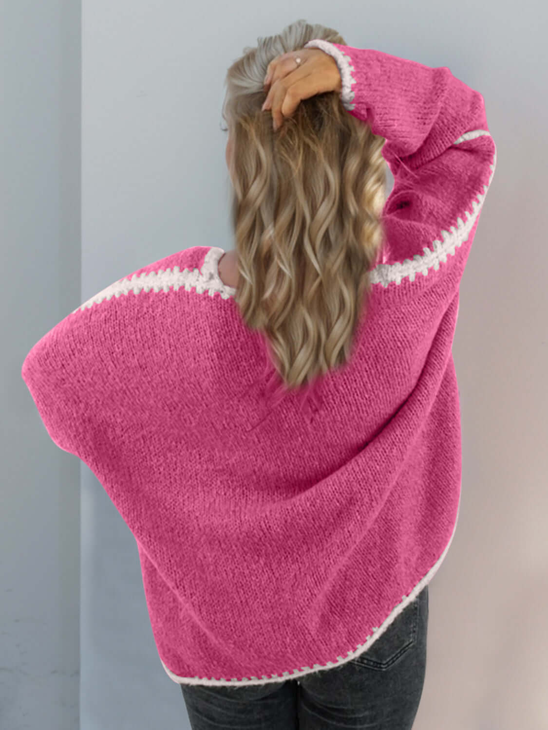 Woman wearing pink dropped shoulder cardigan with open front, showcasing stylish comfort and relaxed fit from the back.