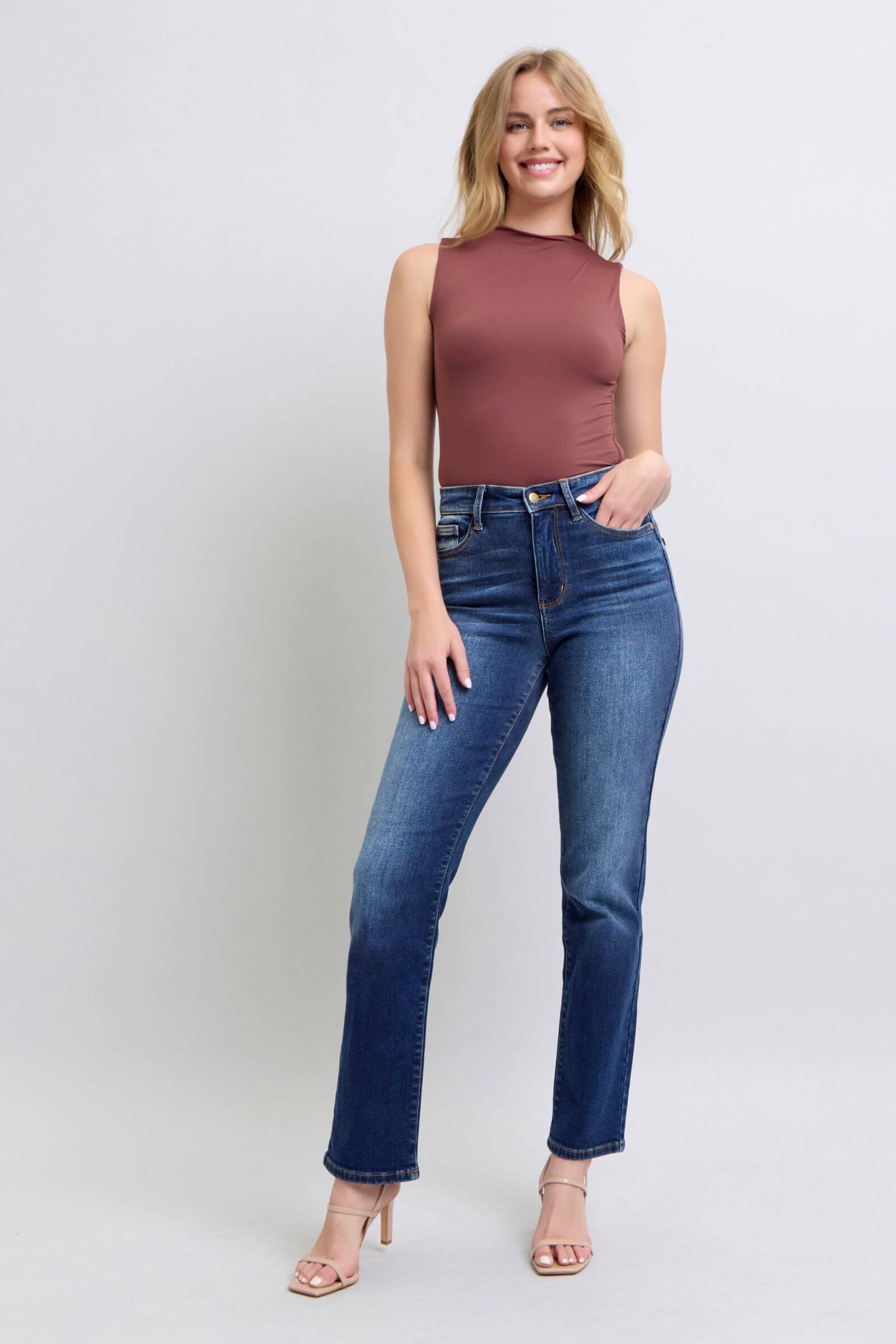 Model showcasing Judy Blue washed straight leg jeans with pockets, paired with a stylish tank top and heels.