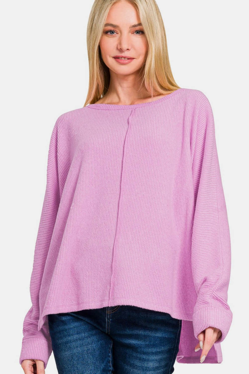 Woman wearing a pink Zenana High-Low Side Slit Round Neck T-Shirt, showcasing its stylish and versatile high-low hemline and side slits.